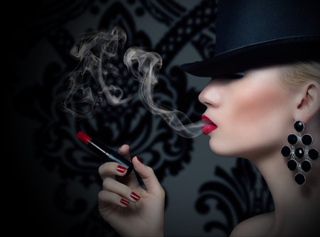 Pretty blonde girl with cigarette and red lipsの写真素材