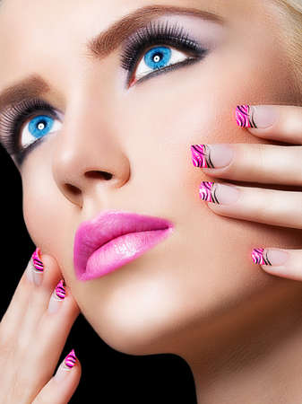 Beautiful blonde girl with pink lips and nails on black backgroundの写真素材