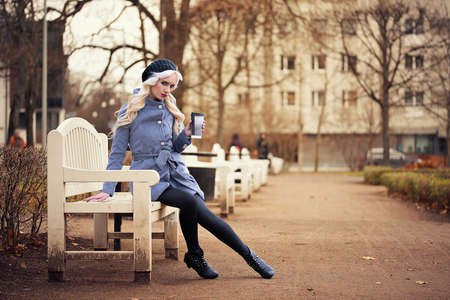 Beautiful blonde woman with coffee outdoorsの写真素材