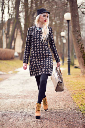 Beautiful blonde young woman walking on the streetの写真素材
