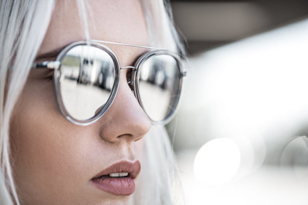 Beautiful blonde girl in sunglassses outdoorsの写真素材