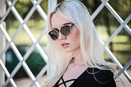 Beautiful blonde girl in sunglassses outdoorsの写真素材