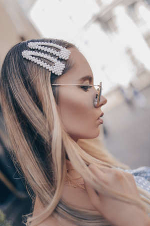 Close up portrait of a young blonde woman with natural hairstyle, wearing pearl hair clips. の写真素材