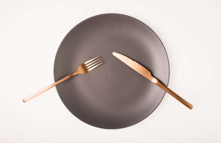 Fork and knife on a empty plateの写真素材