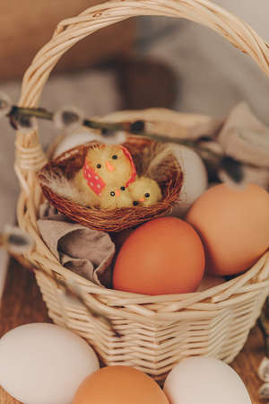 Easter eggs with little chick toys in basket.の写真素材