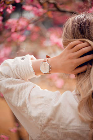 Stylish white watch on woman hand in flowersの写真素材