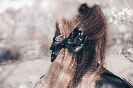 Portrait of a beautiful young woman with long wavy hair with black bow.の写真素材