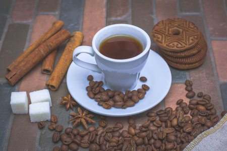 Morning coffee with cookies and cinnamon on a dark background