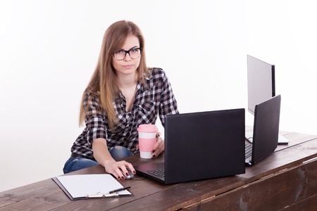 the girl in an Office sitting at a laptop with coffeeの写真素材