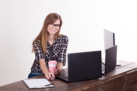 the girl in an Office sitting at a laptop with coffeeの写真素材