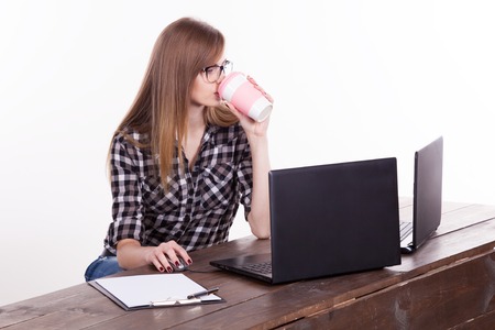 the girl in an Office sitting at a laptop with coffeeの写真素材
