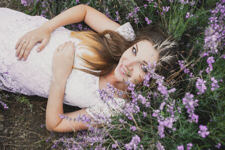 pregnant nice woman girl lies in Lavenderの写真素材