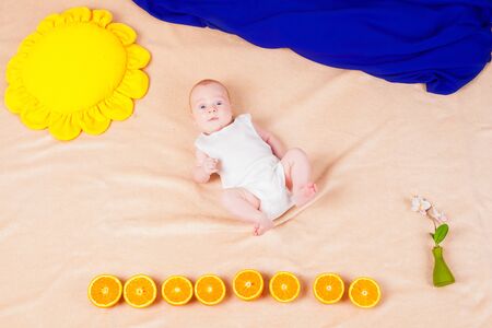 Baby with oranges in a painting from the fabricの写真素材