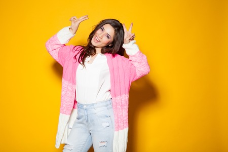 Merry girl on a yellow background indicates winの写真素材