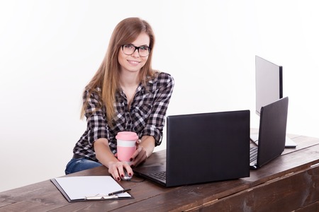 the girl in an Office sitting at a laptop with coffeeの写真素材