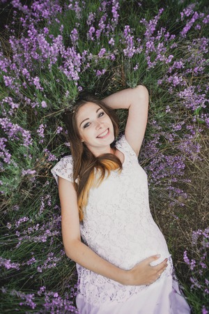 pregnant nice woman girl lies in Lavenderの写真素材