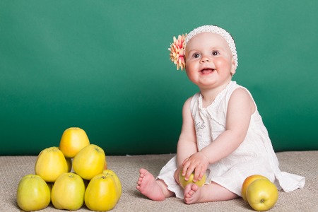 little nice girl with big yellow applesの写真素材