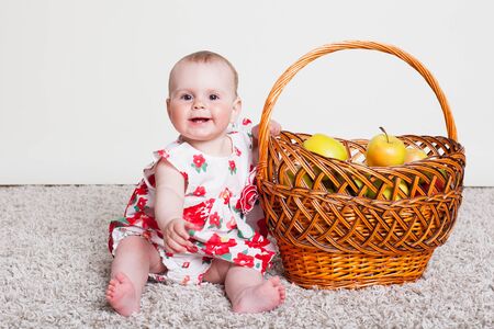 a little kid with a basket with applesの写真素材