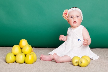 little nice girl with big yellow applesの写真素材