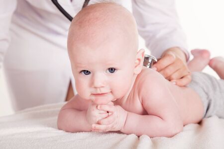 the doctor listens to the baby newbornの写真素材