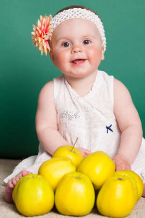little nice girl with big yellow applesの写真素材