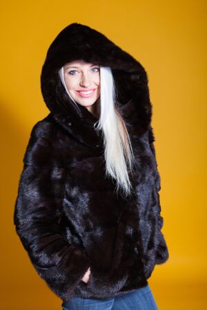 girl in a fur coat poses in a Photo Studioの写真素材