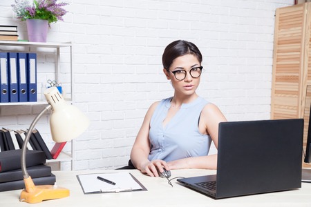 the girl works in an Office at a computerの写真素材