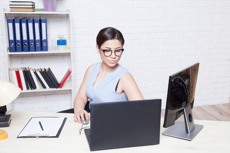 the girl works in an Office at a computerの写真素材