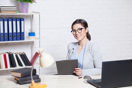 the girl works in an Office at a computerの写真素材