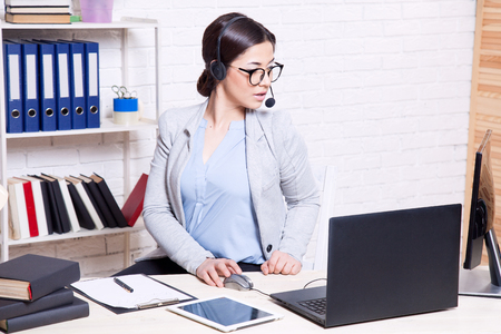 the girl works in an Office at a computerの写真素材