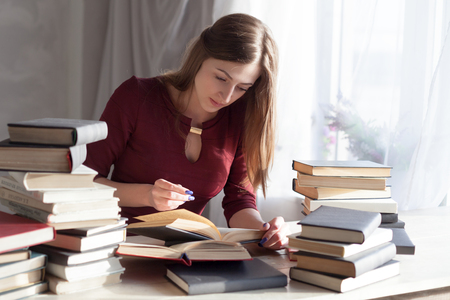 girl sits books and reading a bookの写真素材