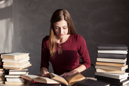girl sits books and reading a bookの写真素材
