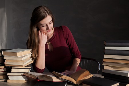 girl sits books and reading a bookの写真素材