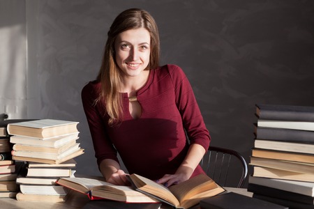 girl sits books and reading a bookの写真素材