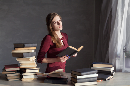 girl sits books and reading a bookの写真素材