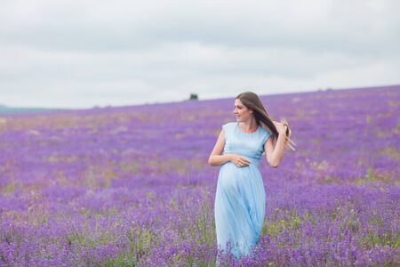 Lavender field and a happy pregnant womanの写真素材