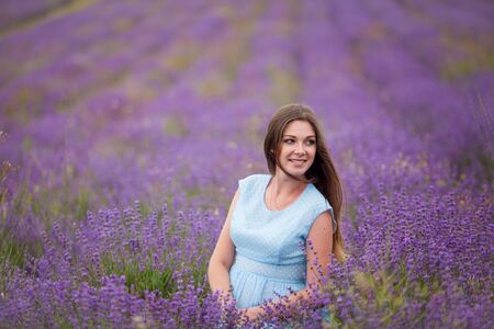 a pregnant woman walks through a field of lavenderの写真素材
