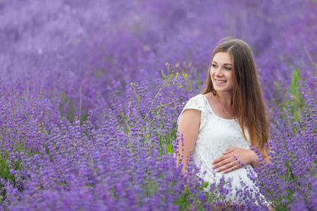 Lavender field and a happy pregnant womanの写真素材