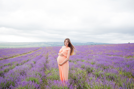 Lavender field and a happy pregnant womanの写真素材