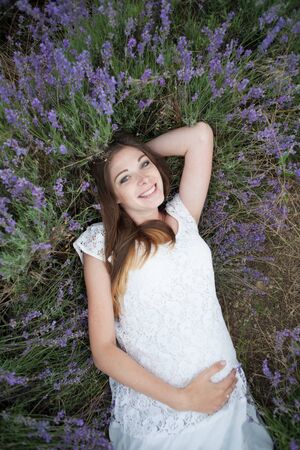Lavender field and a happy pregnant womanの写真素材