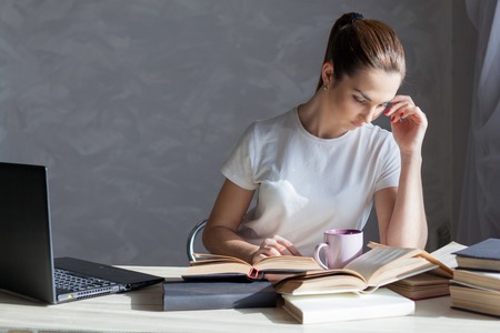 girl is preparing for the exam and reads a bookの写真素材