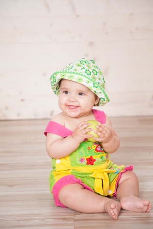 the little girl in the hat sitting on the floorの写真素材