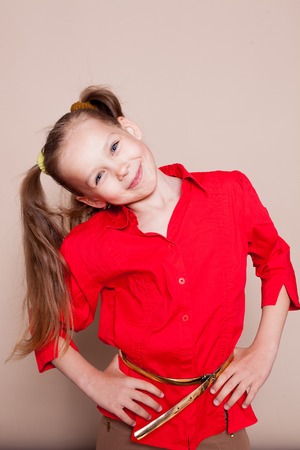little casual girl with pigtails smiling in studioの写真素材