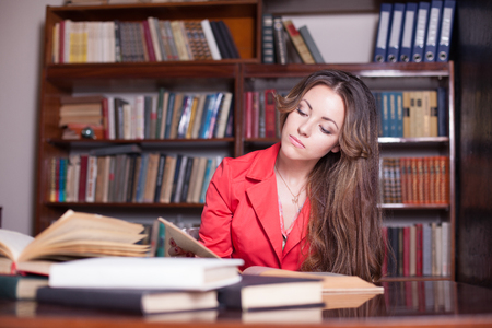 girl reading book in the library is preparing for examsの写真素材