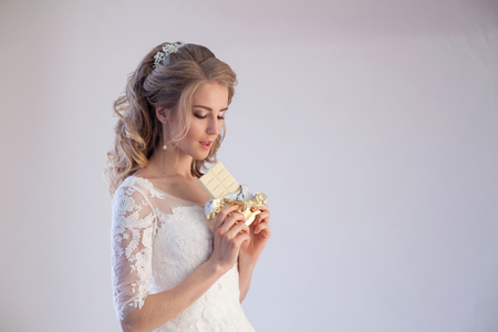 bride in wedding dress holding a chocolateの写真素材