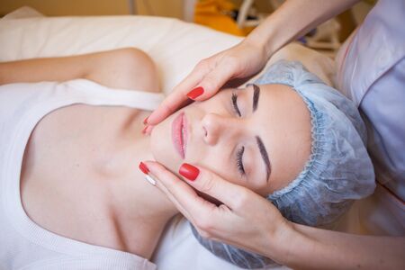 doctor cosmetologist doing facial massage girl spaの写真素材