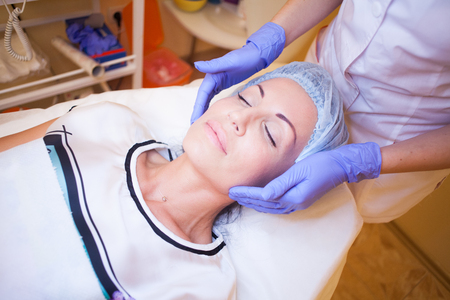 doctor cosmetologist makes a woman face Massageの写真素材