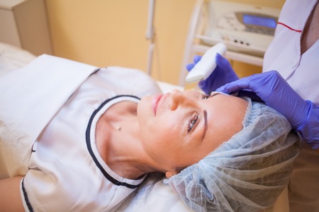 the doctor makes a woman patient procedures esthetician on face Spaの写真素材