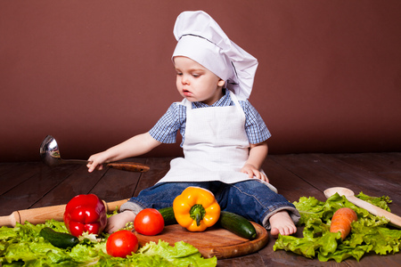 little boy Cook carrots, peppers, tomatoes, lettuce,の写真素材