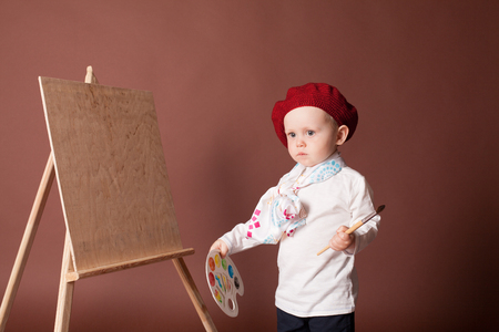 little boy artist brush and paints paints a pictureの写真素材